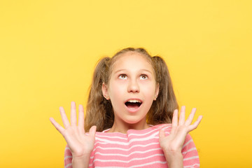 surprised shocked astonished amazed girl looking up above her head. emotional facial expression.