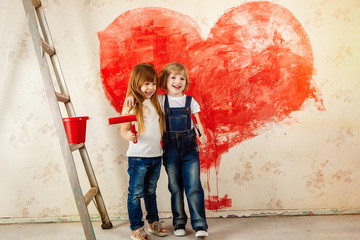 Children painted wallpaper in the room with red paint. Paint the walls with a roller. A girl and a boy painted a heart on the wall in the house. Valentine's Day, a gift to parents.