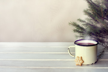 hot drink with mood retro iron mug with mulled wine stands on the table under the Christmas tree