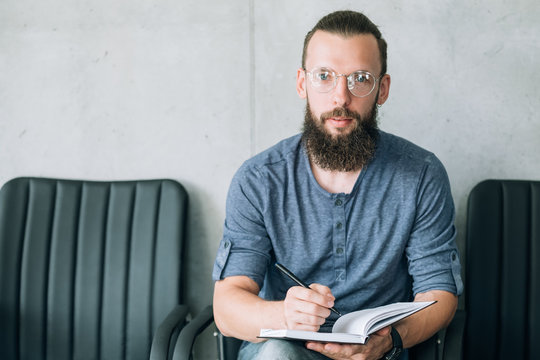 Man Sitting In The Row Of Empty Chairs. Interview Or Job Hiring Concept.