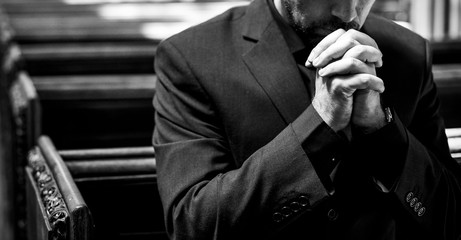 Lonely Christian man praying in the church