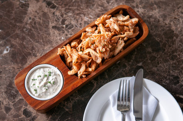 Crunchy deep fried calamari with Tartar sauce in wood plate