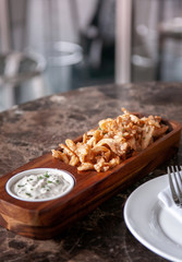 Crunchy deep fried calamari with Tartar sauce in wood plate