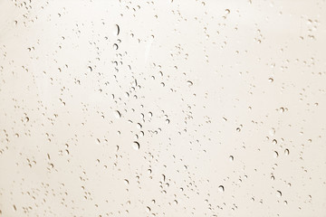 Naklejka premium Blured water drops on window in brown tone.