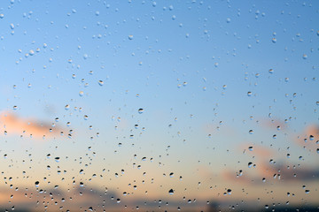 Rain drops on window with blured background.