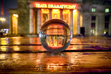 WARSAW, POLAND - NOVEMBER 3, 2018: Dramatic Theater in Palace of Culture and Science, Warsaw, Poland. Night view through a glass, crystal ball (lensball) for refraction photography.