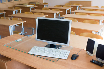Computer on teacher`s table in auditorium
