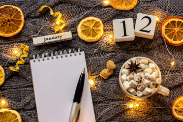 calendar January 12th Cup of cocoa and empty open notepad