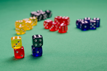 many multi-colored cubes lie on the green table
