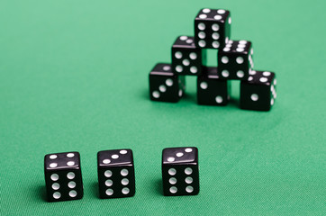 lot of black dice on a green background