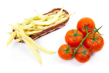 Fresh young pods of beans with beans and bunch of the fresh red tomatoes with water drops on white background..