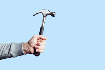 Hammer in hand isolated. Man holding a hammer, tool in the hand.