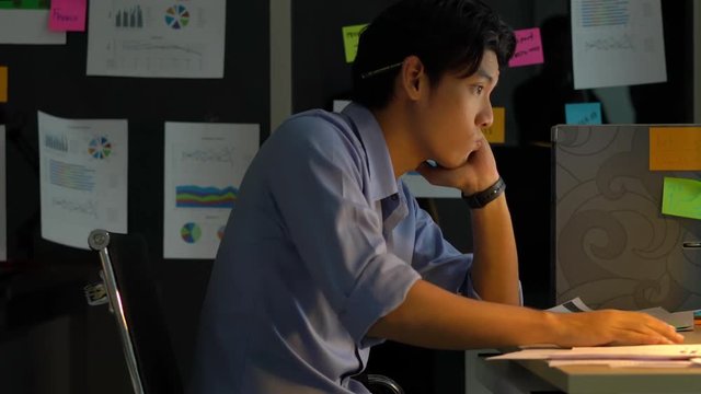 Businessman hard working with desktop computer to late night at office. Business people work overtime. Concept of salary man, fatigue and tired.