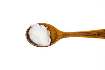 Solid virgin coconut oil or copra oil, is an edible oil. On brown wooden spoon isolated on white....