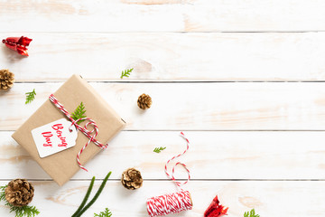Boxing day Sale text on a white tag with gift box, pine cones, red bell on a wooden white background. Online Shopping concept.