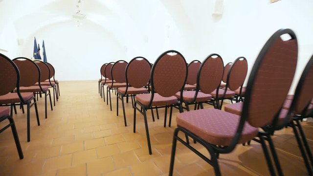 Walk through seminar hall with seats in rows 4K. Gimbal stabilizer movement beside chairs in rows inside the lecture room.