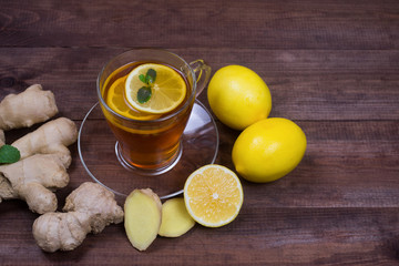Ginger tea with lemon and  mint on a wooden table.The concept of health.Drink rich of vitamins for winter time in cold days.