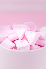 Cup of pink marshmallow hearts on a pink background. Valentines day love concept. Copy space
