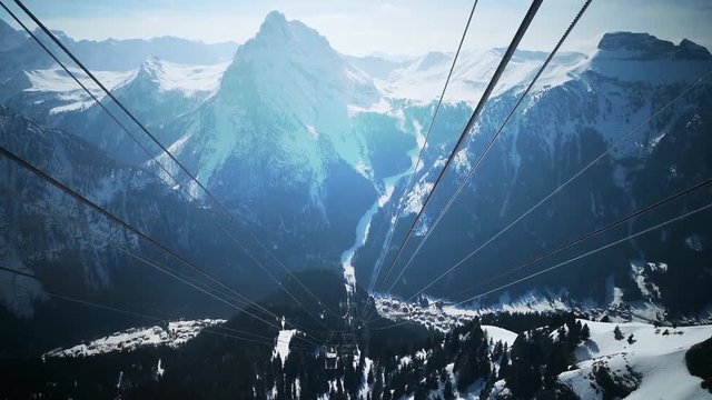 Footage of some snowy mountains viewed from a cable car.