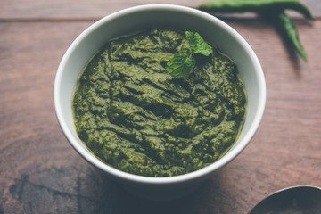Healthy Indian Green Chutney or Sauce Made using Coriander, Mint And Spices. isolated over moody background. Selective focus