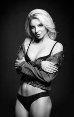 Studio fashion shot: beautiful sexy young girl in jean jacket and lingerie. Black and white