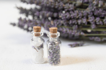 Natural herbal sea salt with aromatic lavender - perfect for relaxation. Cosmetic jars and bottles with salt, lavender flowers, bath bomb