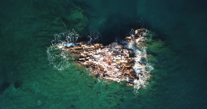 Rock formation in the Ionian sea being hit by crashing waves located in Ksamil Saranda / Sarande, Albania (Albanian Riviera) - 4k