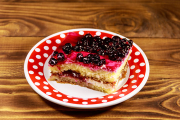 Tasty cheesecake with black currant on wooden table