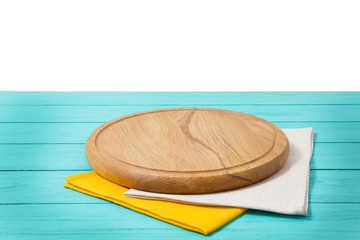Round pizza cutting board and tablecloth on blue wooden background isolated on white. Top view. Copy space and mock up. Place for food and drink. Picnic and thanksgiving day concept.