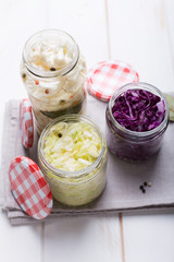 Sauerkraut in jars on a wooden table. Top view