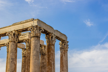 Fototapeta premium marble columns shape in golden yellow color from evening sunset sun light on blue sky background with empty space for copy or text