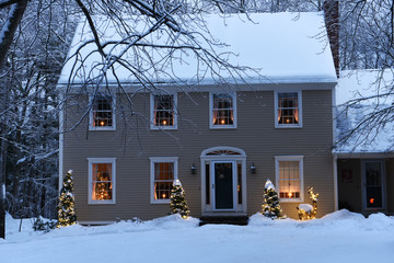 House in the forest with glowing windows and candles and a Christmas tree. The atmosphere of the holiday of Christmas and the new year.
