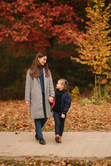 Two sisters walk in the park in autumn time. Childhood. season and people consept-happy family
