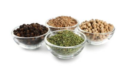 Glass bowls with different spices on white background
