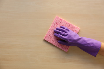 Woman cleaning wooden surface, top view