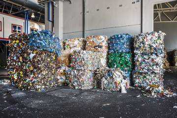 Plastic bales of rubbish at the waste treatment processing plant. Recycling separatee and storage of garbage for further disposal, trash sorting. Business for sorting and processing of waste.