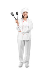 Young female chef with kitchenware on white background