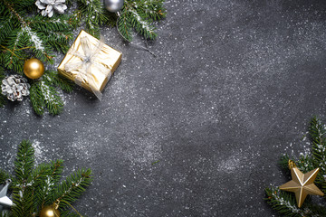 Christmas background with gold and silver decorations on black.