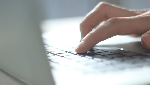 close up. blurred image of male hand typing on laptop keyboard