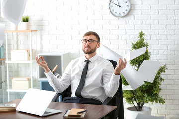 Naklejka premium Businessman with a lot of work to do meditating in office