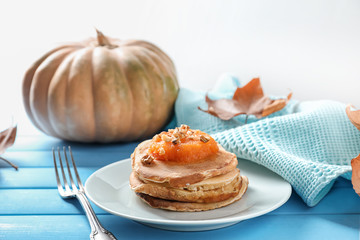 Stack of hot tasty pancakes with pumpkin on plate
