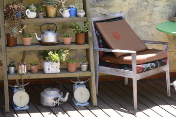 relaxing spot next to old pots and plants shelf in the garden