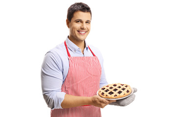 Handsome man with apron holding a cherry pie