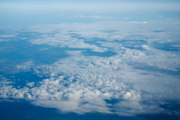 Naklejka na ściany i meble Clouds and blue sky, a view from airplane window