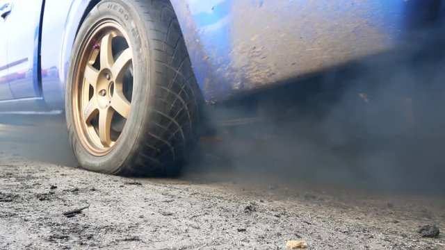 Drag car make tires warm up with smoke, Car racing burnout rubber off its tires in preparation for the race.