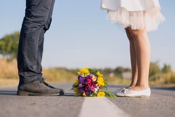 bride and groom standing on road with bouquet on ground. bride flowers isolated.