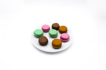 Obraz na płótnie Canvas macarons on plate, sweet colorful macarons on white background