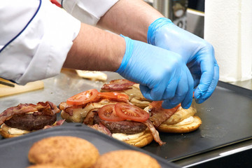 The chef prepares many hamburgers on the table in the restaurant.