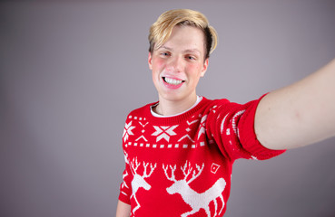 Boy taking an selfie with christmas jumper