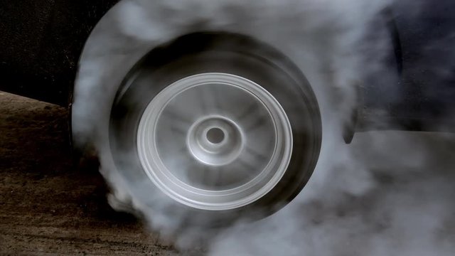 Drag car make tires warm up with smoke, Car racing burnout rubber off its tires in preparation for the race.